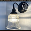 Antique 1950s Bell Holophane glass wall sconce; clear glass shade, black metal.