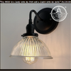 Glass wall sconce with ribbed Holophane shade, black metal, The Lamp Goods.