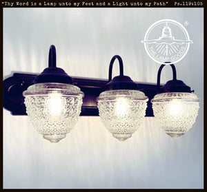 Antique Acorn Glass Vanity Light, 3-light black fixture with clear glass shades.