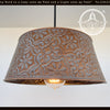 Ornate copper pendant light fixture with embossed floral pattern.