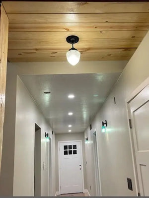 Antique glass ceiling light fixture in hallway with wood ceiling
