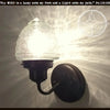 Glass torch wall sconce with textured glass shade & black metal base.