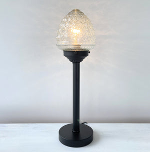Elegant tall glass table lamp with a textured shade and black metal base.