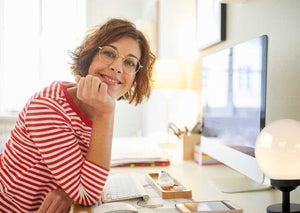 White milk glass globe lamp on a home office desk.