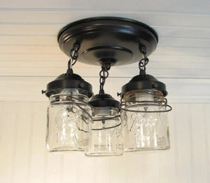Three-light vintage mason jar ceiling fixture with dark bronze metal accents.