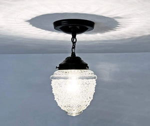 Clear glass ceiling light fixture with textured globe, black metal chain & mount.