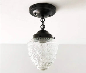 Clear glass ceiling light fixture with textured globe shade and black metal accents.