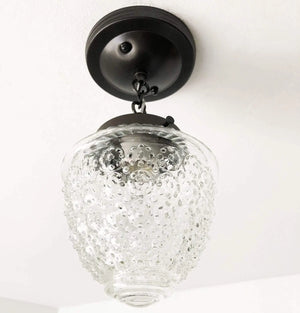 Clear glass ceiling light fixture with textured bubble pattern, black metal chain and mounting plate.