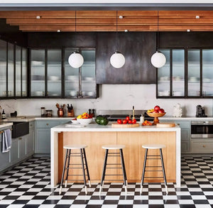 Milk glass globe pendant lights illuminating a modern kitchen island.
