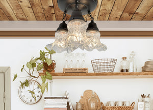 Antique glass hobnail ceiling light fixture, three-light design, installed on wood ceiling, above kitchen shelving.
