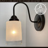 Modern Farmhouse linen & clear glass wall sconce; black metal, warm light.
