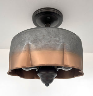Metal ceiling light fixture with copper bottom, installed on a white ceiling.
