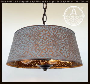 Copper farmhouse chandelier with ornate, embossed metal shade in blue and copper tones.
