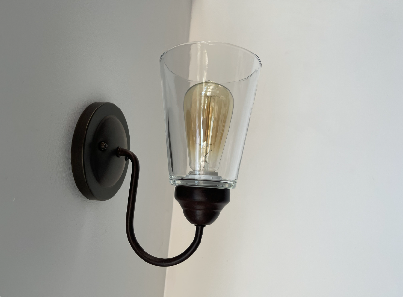 Modern farmhouse wall sconce with clear glass shade and Edison bulb.
