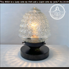 Antique glass table lamp with textured shade, dark base.
