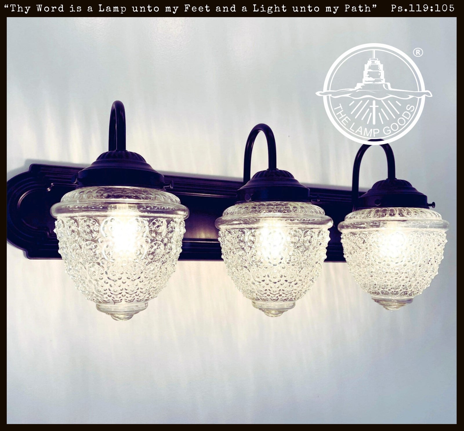 Antique Acorn Glass Vanity Light, 3-light black fixture with clear glass shades.
