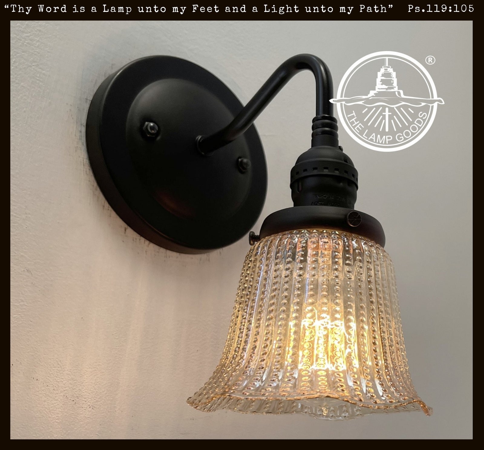 Antique 1930s amber glass hobnail wall sconce with black metal accents.
