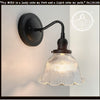 Antique Holophane glass wall sconce with ribbed dome shade & black metal arm.
