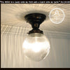 Clear glass Holophane ceiling light fixture with black metalwork.
