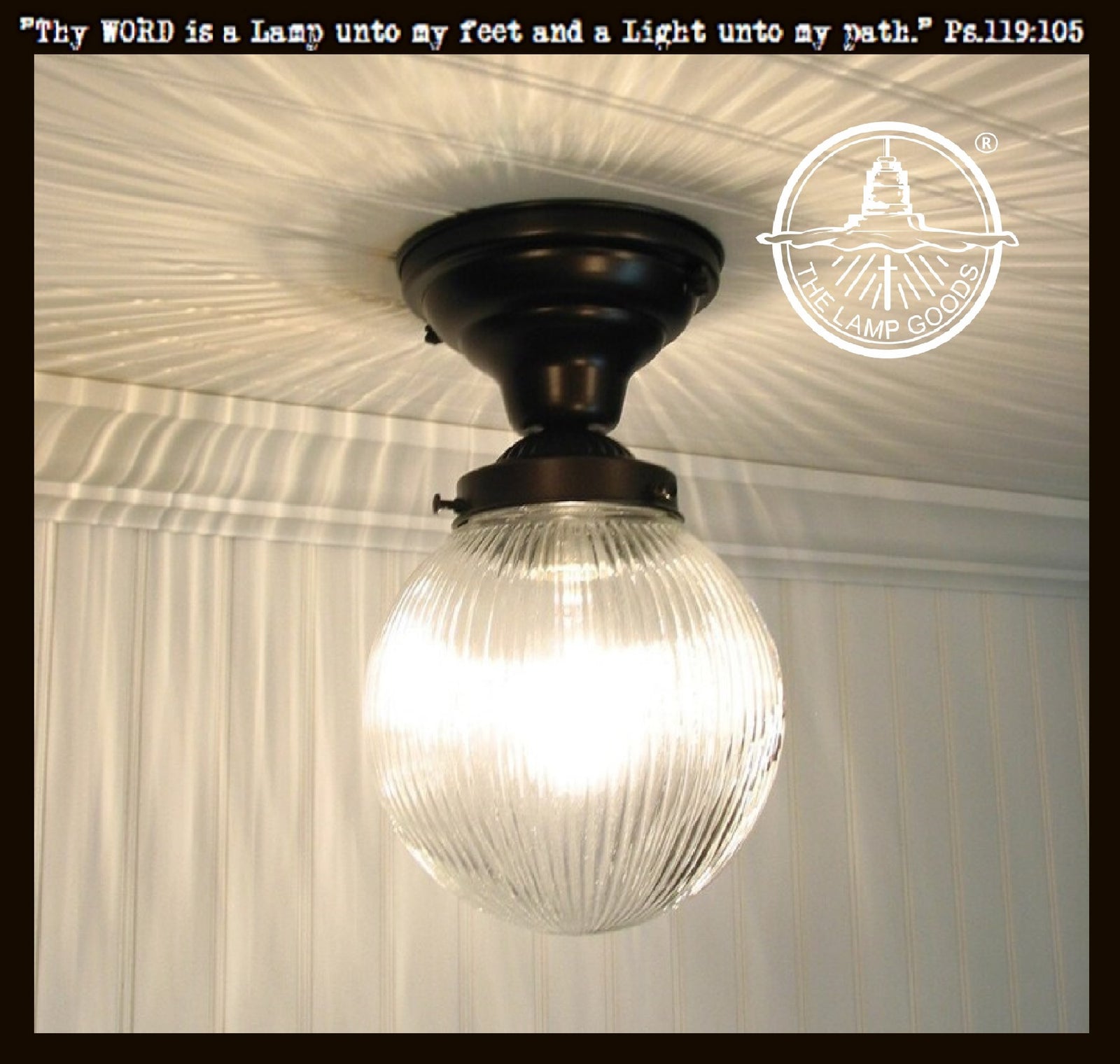 Clear glass Holophane ceiling light fixture with black metalwork.
