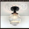 Modern Holophane glass ceiling light with black metal canopy; clear ribbed glass globe.
