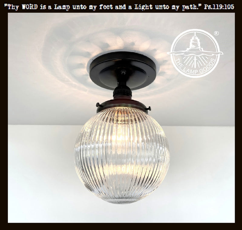 Modern Holophane glass ceiling light with black metal canopy; clear ribbed glass globe.
