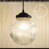 Antique large glass Holophane pendant light with ribbed glass shade and black metal fixture.

