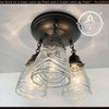 1960s pressed glass ceiling light fixture trio; clear glass shades, black metal frame.
