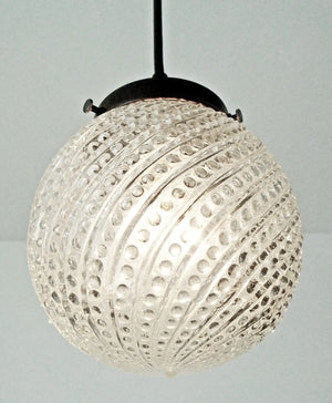 Clear glass pendant light fixture with hobnail swirl pattern.
