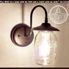 Mason jar outdoor porch wall sconce light; dark bronze finish, clear glass.
