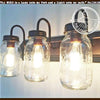 Triple Mason jar bathroom vanity light fixture with dark bronze accents.
