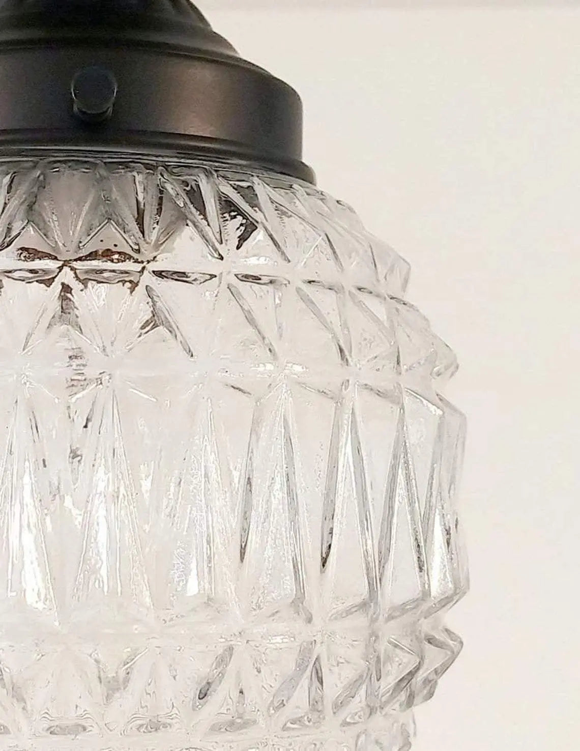 Clear glass pendant light with geometric pattern, bronze fitting.
