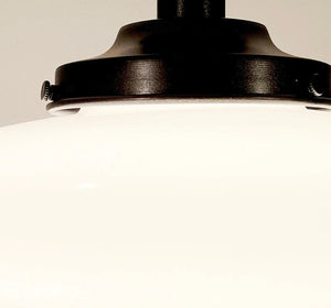 Close-up of antique milk glass ceiling light fixture with dark bronze metal accents.
