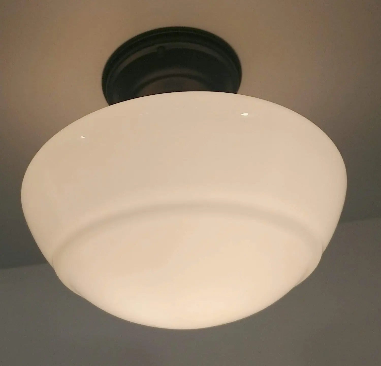 Cream-colored milk glass ceiling light fixture with dark bronze mounting.
