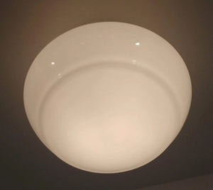 Milk glass ceiling light fixture, softly illuminated.
