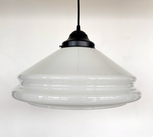 Milk glass pendant light with layered, curved design and black metal fixture.
