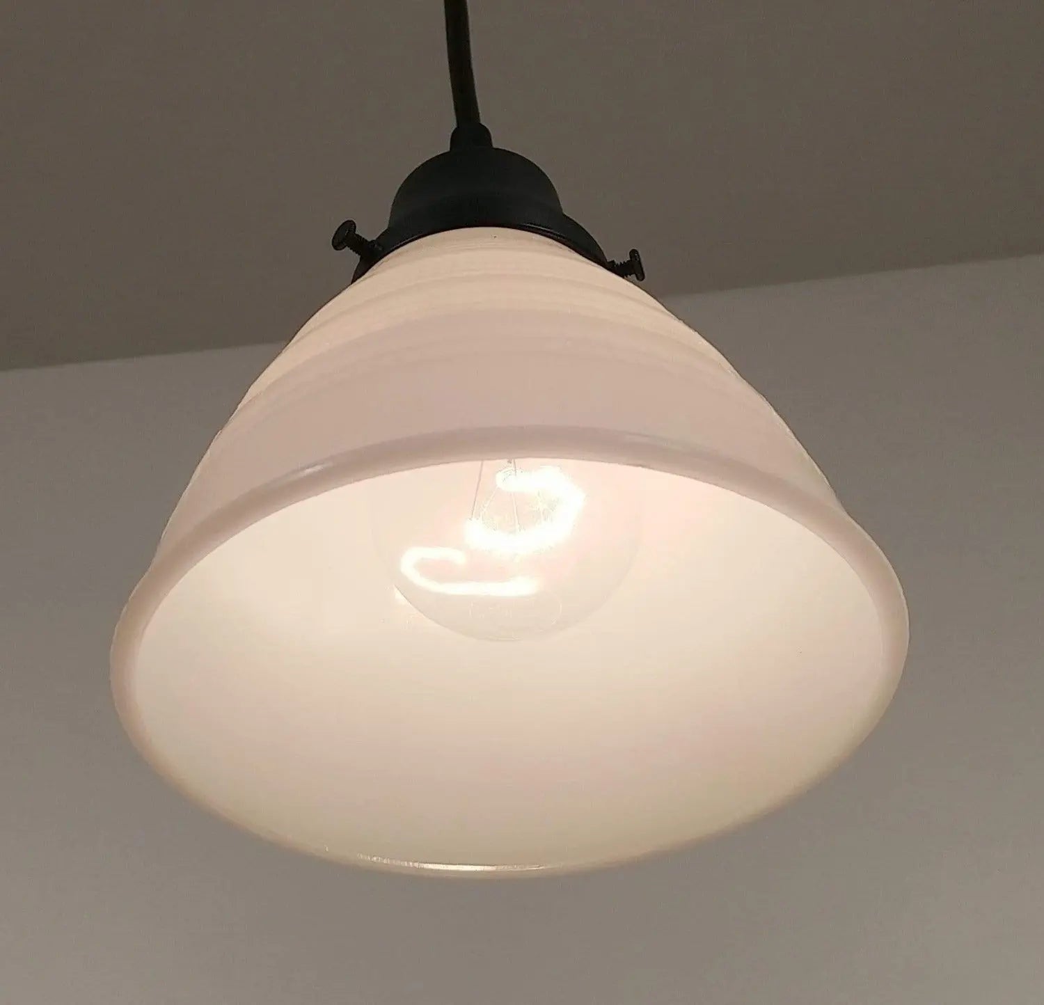 Cream-colored milk glass pendant light fixture with a waffle texture and black metal accents.
