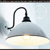 Large white enamel wall sconce with black arm; The Lamp Goods.
